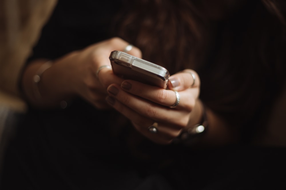 Seseorang memegang ponsel, merepresentasikan pembaca Mpo77 yang mengakses informasi dari perangkat seluler
